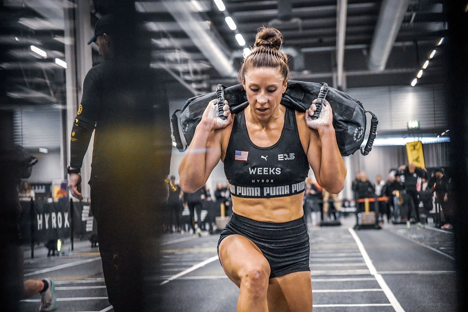 Athlete performing lunges with a sandbag across their shoulders at HYROX Stockholm