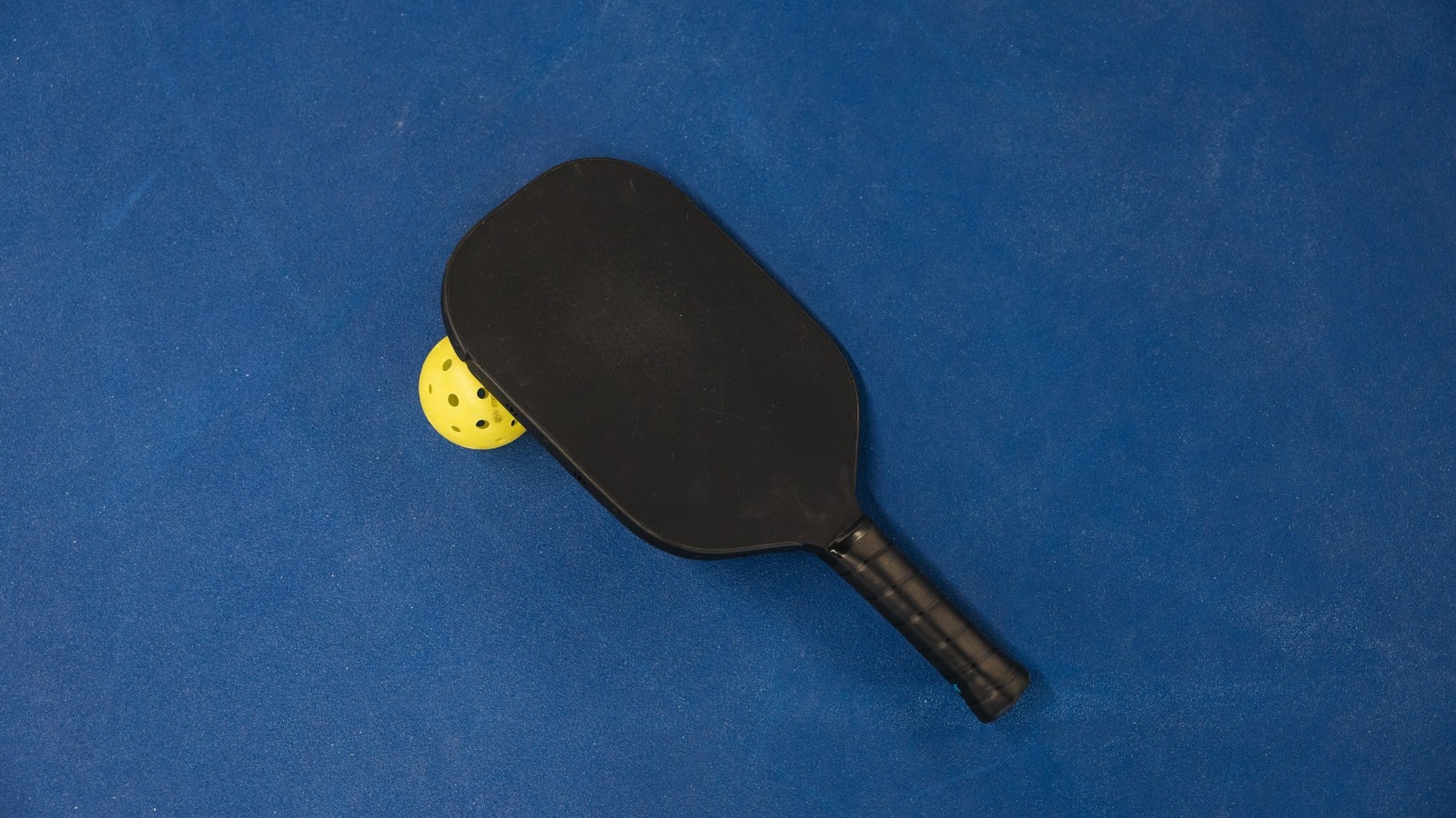 Siyah karbon fiber pickleball raketi ve topu