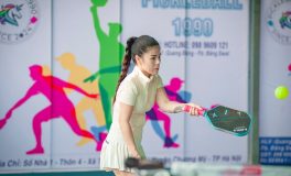 Pickleball kortunda beyaz kıyafetle raketiyle vuruş yapan kadın oyuncu