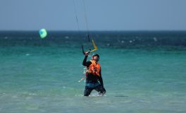 Wetsuit ve can yeleğiyle denizden çıkan kitesurfçü — tuzlu su sonrası ekipman bakımı