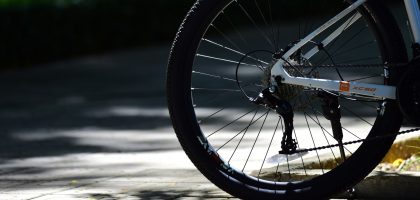 Kaldırım kenarında duran bir bisikletin arka tekeri, tırtıklı lastiği ve vites takımı yakın plan