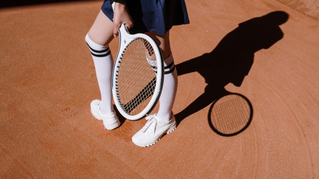 Grip ölçüsü uygun raketi toprak kortta elinde tutan tenis oyuncusu