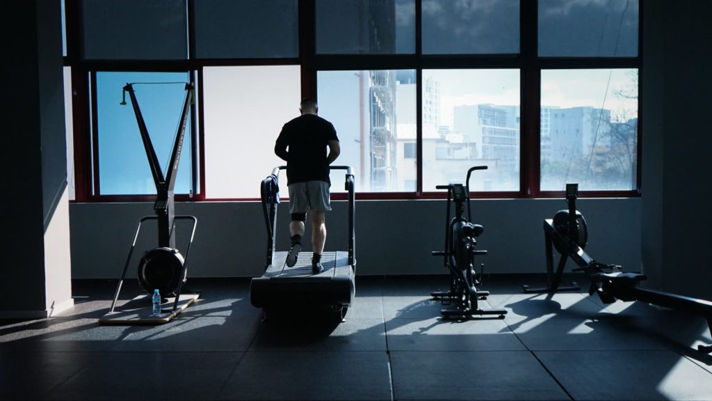 Eine Person läuft auf einem Laufband am Fenster im Fitnessstudio: Vor der Einheit das Gerät kennenlernen